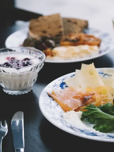 Breakfast with sandwich, juice, coffee, and yogurt.